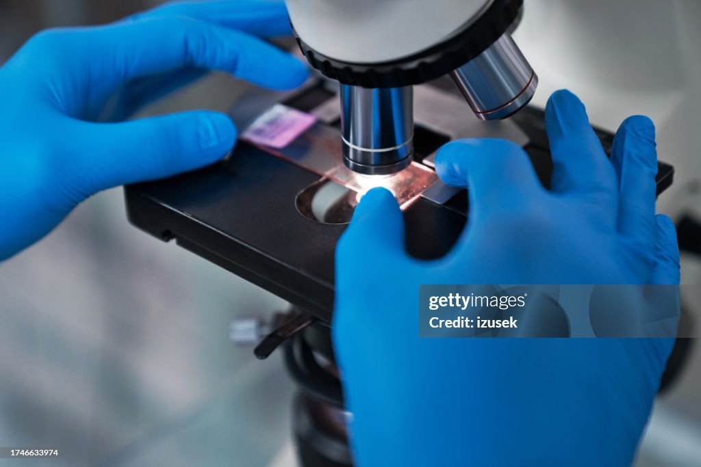 Cropped image of scientist with microscope
