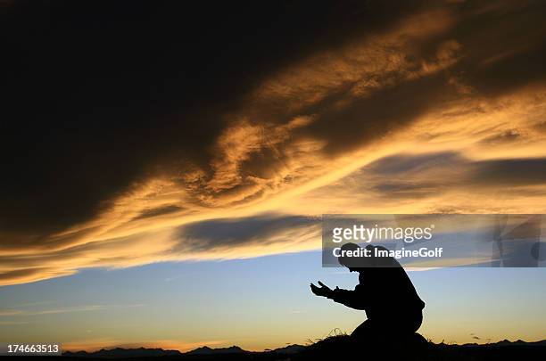 adult man meditating at sunset - god worship stock pictures, royalty-free photos & images