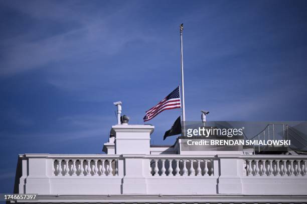 The US flag flies at half-staff atop the White House in Washington, DC, on October 26, 2023 after a gunman killed 18 people in Lewiston, Maine....