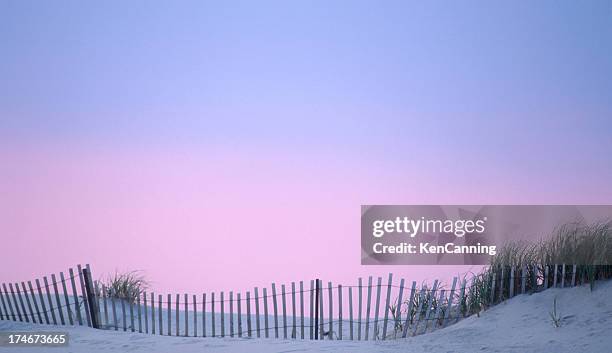 dunas vedação na praia com céu pôr do sol - condado de cape may imagens e fotografias de stock