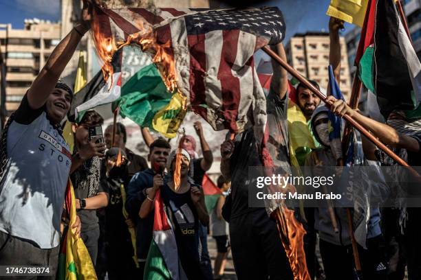 Young supporters of Hezbollah burn a US flag during a rally in support of Palestinians in Gaza on October 20, 2023 in Beirut, Lebanon. There has been...