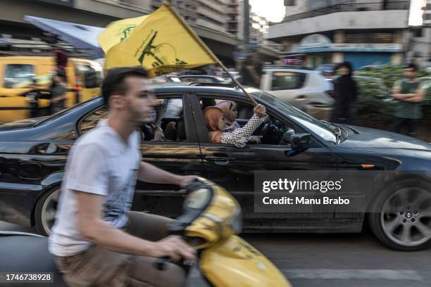 Lebanese women, supporters of Hezbollah, wave Hezbollah flags from the window of their car after a rally in support of Palestinians in Gaza on...
