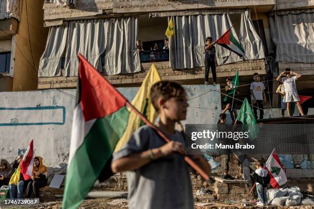 Lebanese kids wave Palestinian, Hezbollah and Amal movement flags during a rally in support of Palestinians in Gaza on October 20, 2023 in Beirut,...