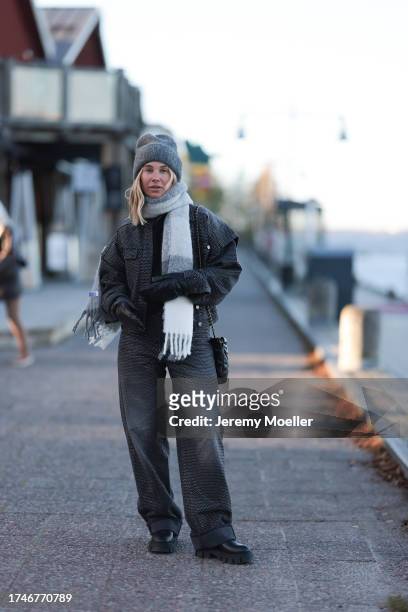 Karin Teigl seen wearing grey wool beanie hat, black knit pullover, Copenhagen Studios grey checked wool knit oversized scarf, dark grey glitter...