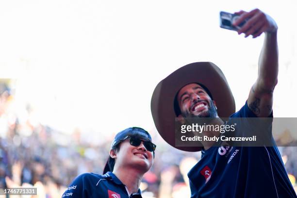 Daniel Ricciardo of Australia and Scuderia AlphaTauri and Yuki Tsunoda of Japan and Scuderia AlphaTauri pose for a selfie on the fan stage prior to...
