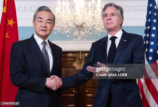 Secretary of State Antony Blinken shakes hands with Chinese Foreign Minister Wang Yi prior to meetings at the State Department in Washington, DC,...