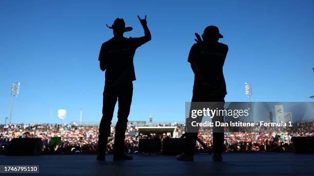 Daniel Ricciardo of Australia and Scuderia AlphaTauri and Yuki Tsunoda of Japan and Scuderia AlphaTauri talk to the crowd on the fan stage prior to...