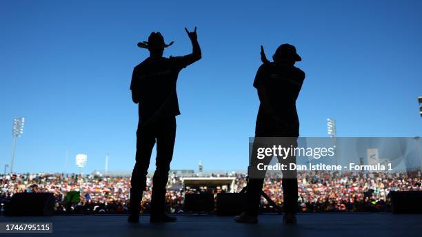 Daniel Ricciardo of Australia and Scuderia AlphaTauri and Yuki Tsunoda of Japan and Scuderia AlphaTauri talk to the crowd on the fan stage prior to...