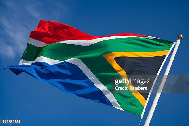 flag of south africa blowing in wind against blue sky - south africa flag stock pictures, royalty-free photos & images