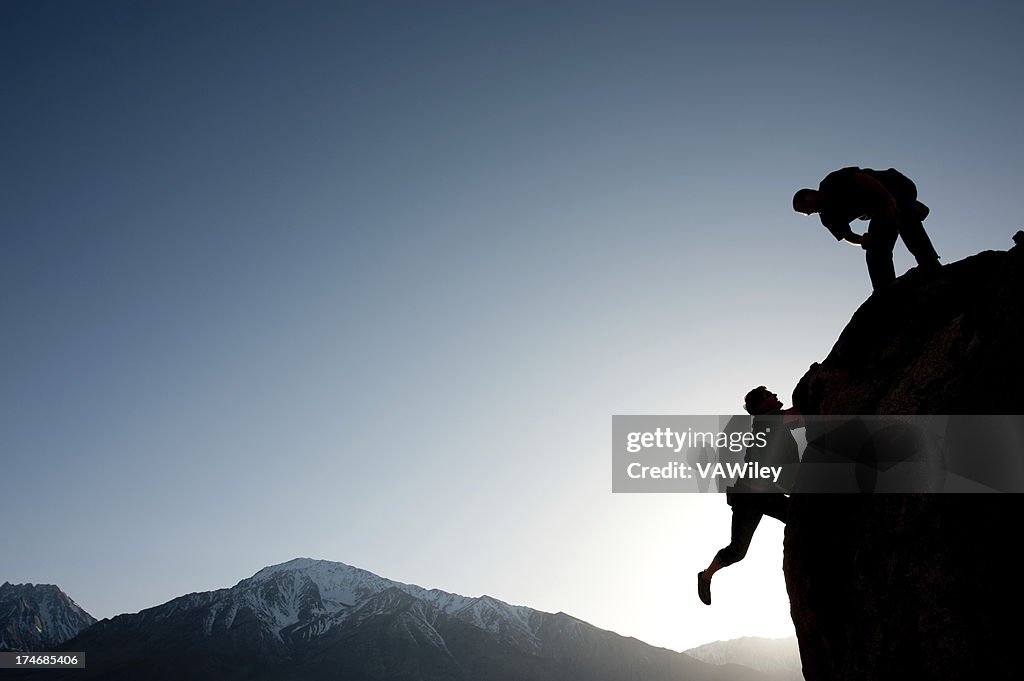 Silhouette of climbers on a rock