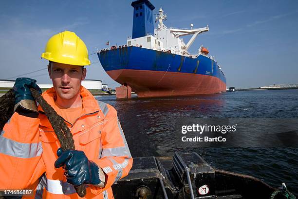 arbeiten im hafen zwischen große containerschiffe. - nautische ausrüstung stock-fotos und bilder
