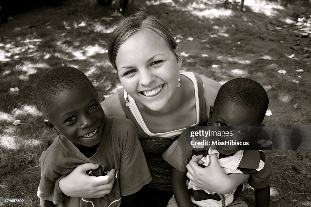 Teen hugging two young children