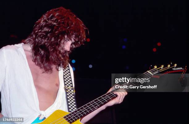 English Rock musician Rick Savage, of the group Def Leppard, plays bass guitar as he performs onstage at Nassau Coliseum , Uniondale, New York,...