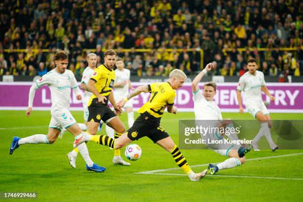 Marco Reus of Borussia Dortmund runs with the ball whilst being under pressure from Jens Stage of Werder Bremen during the Bundesliga match between...