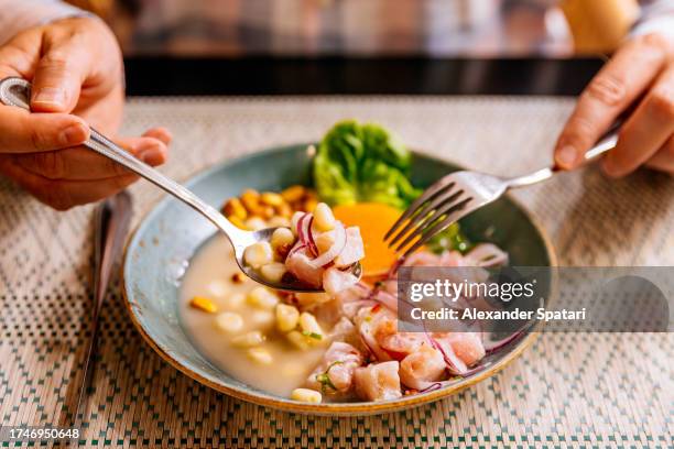 man eating raw fish ceviche at the restaurant, close-up view - culture péruvienne photos et images de collection