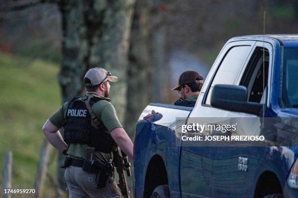 Police guard the road to Robert Card's father's home in Bowdoin, 15 miles away from Lewiston, Maine on October 26, 2023 the day after a mass...