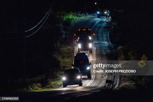 Convoy of law enforcement vehicles leaves the homes of Robert Card's father and brother in Bowdoin, 15 miles away from Lewiston, Maine on October 26,...