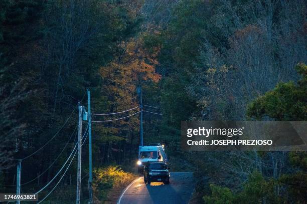 Law enforcement vehicles sit on the road leading to the home of Robert Card's father in Bowdoin, 15 miles away from Lewiston, Maine on October 26,...