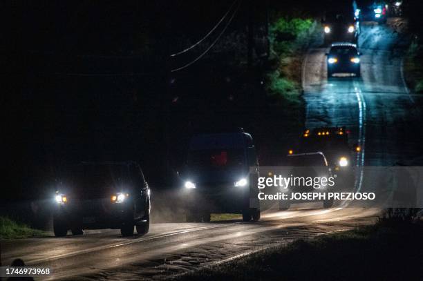 Convoy of law enforcement vehicles leaves the homes of Robert Card's father and brother in Bowdoin, 15 miles away from Lewiston, Maine on October 26,...