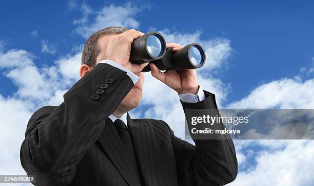 a businessman looking through binoculars - looking through binoculars stock pictures, royalty-free photos & images