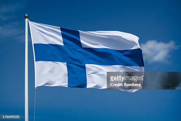 hoisted finnish flag with a blue sky background - finland stock pictures, royalty-free photos & images
