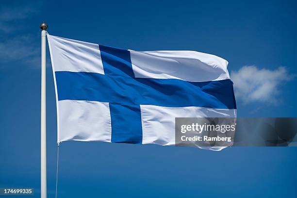 hoisted finnish flag with a blue sky background - finish flag stock pictures, royalty-free photos & images