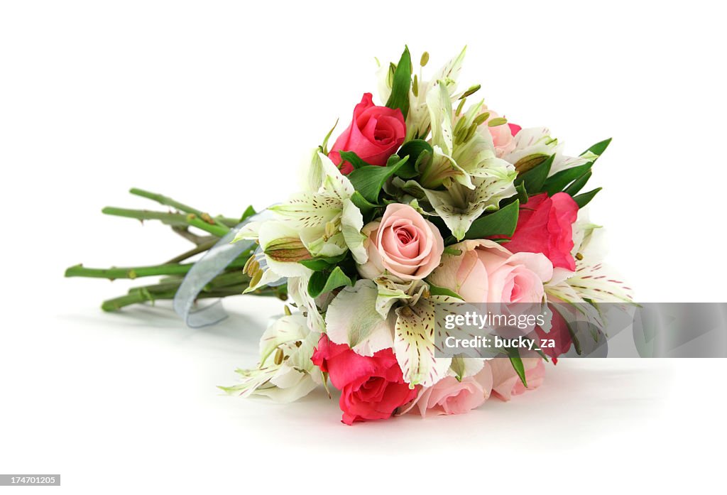 Multi flower bouquet tied with white ribbon lying on side