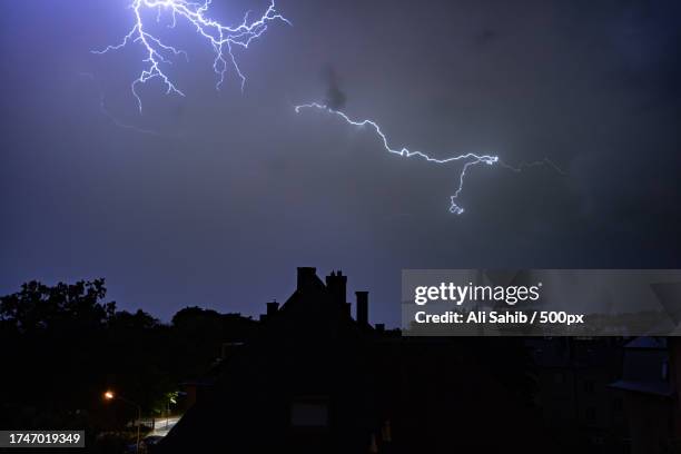 low angle view of lightning in sky at night,district luxembourg,luxembourg - thunderstorm stock pictures, royalty-free photos & images