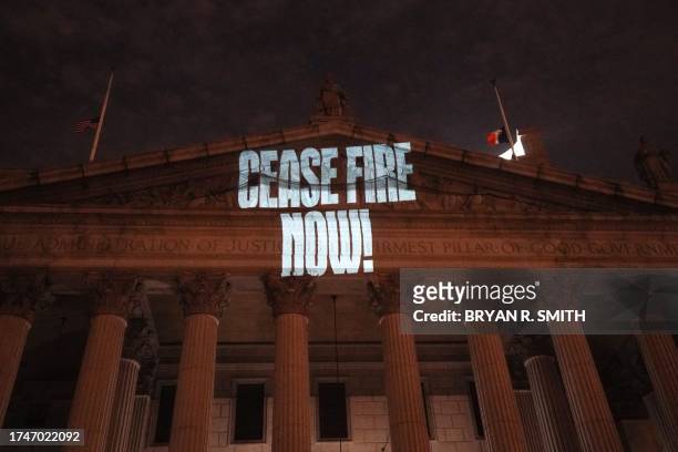 Protesters display images on a lower Manhattan courthouse during "Flood Wall St. For Gaza" rally outside the New York Stock Exchange in New York on...