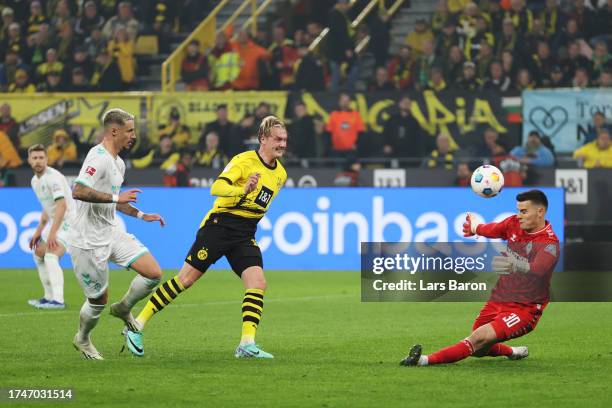 Julian Brandt of Borussia Dortmund scores the team's first goal past Michael Zetterer of Werder Bremen during the Bundesliga match between Borussia...