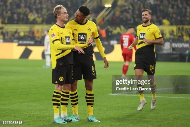 Julian Brandt of Borussia Dortmund celebrates with Felix Nmecha after scoring the team's first goal during the Bundesliga match between Borussia...