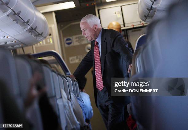 Republican Presidential hopeful John McCain speaks with staff as he travels on February 5, 2008 from San Diego to Phoenix to await the results of the...