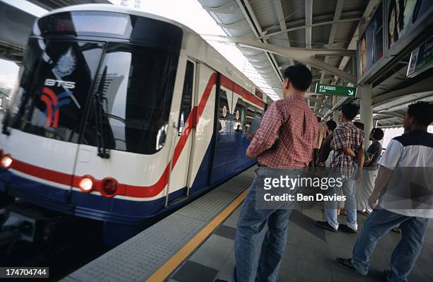 Passengers wait to board the BTS Skytrain, an elevated commuter train that is travelling through the heart of Bangkok, the Thai capital. Bangkok is...