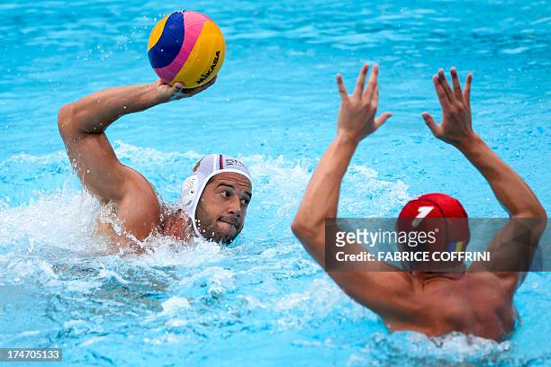 Serbia's Vanja Udovicic scores against Romania's goalkeeper Dragos Stoenescu during their men's water polo quarterfinals qualification match at the...