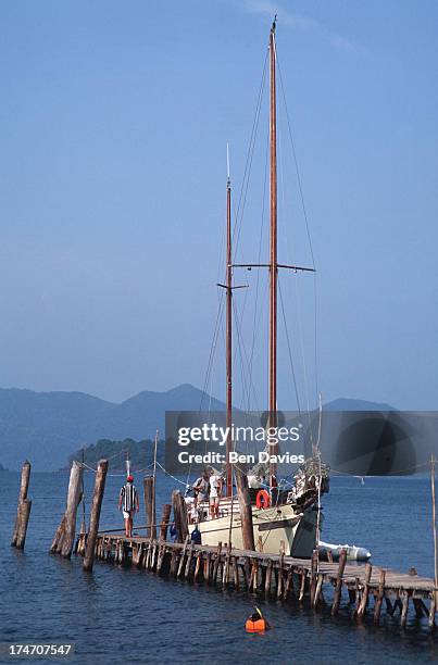 Tourists relax on a luxury yacht moored alongside one of the islands of the Koh Chang National Marine Park in the Gulf of Thailand. The park is made...