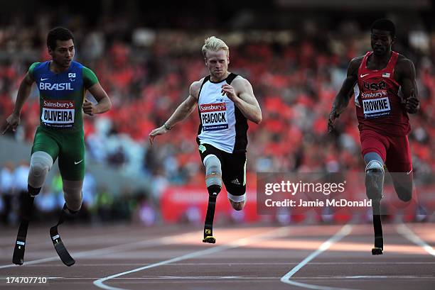 Alan Oliveira of Brazil crosses the line ahead of Jonnie Peacock of Great Britain and Richard Browne of United States in the Mens T43/44 100mduring...