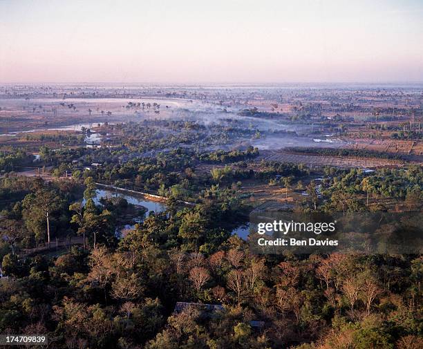 Dawn over the sparsely forested plains of Nong Khai Province near the hilltop retreat at Wat Phu Tok. Known as Isaan, Thailand's northeast region is...