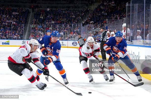 Brock Nelson and Bo Horvat of the New York Islanders battles for the puck with Jake Sanderson amd Travis Hamonic of the Ottawa Senators during the...