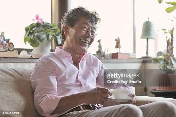 Senior man drinking coffee while sitting on a couc