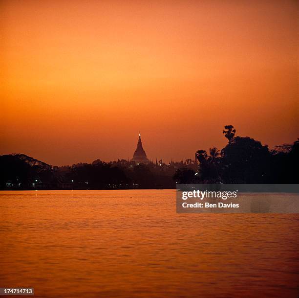 Sunset over the famous Shwedagon Pagoda in Yangon, Myanmar. Known as the Golden Pagoda, the Shwedagon was built according to legend, some 2,500 years...
