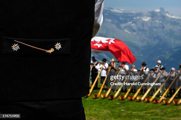 Detail of an alphorn player adorns a jacket as alphorn players perform on July 28, 2013 in Nendaz, Switzerland. About 150 alphorn blowers performed...