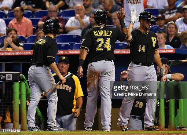 Pedro Alvarez of the Pittsburgh Pirates is congratulated by Gaby Sanchez after scoring on an RBI double by Russell Martin during a game against the...