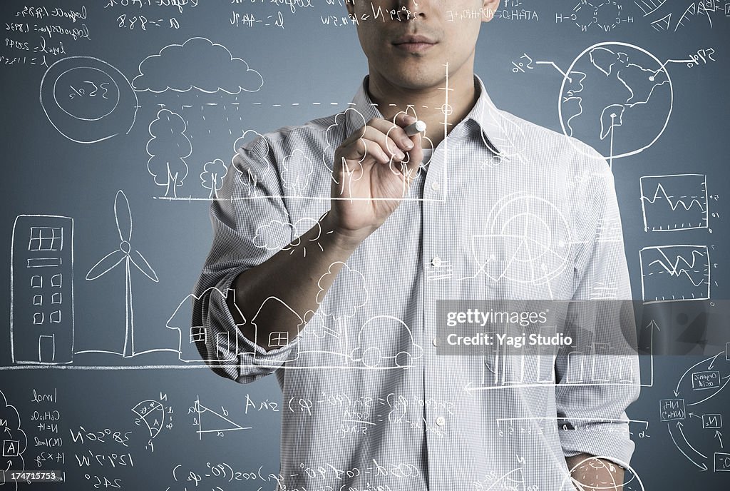 Man writting a formula and picture in chalk