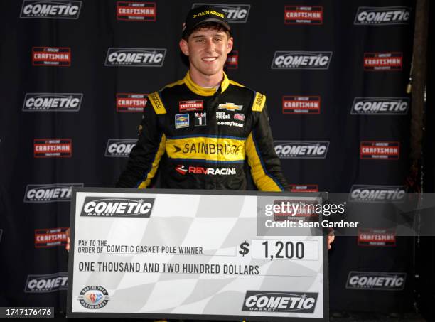 Nick Sanchez, driver of the Gainbridge Chevrolet, poses with the pole award winner $1,200.00 check during qualifying for the NASCAR Craftsman Truck...