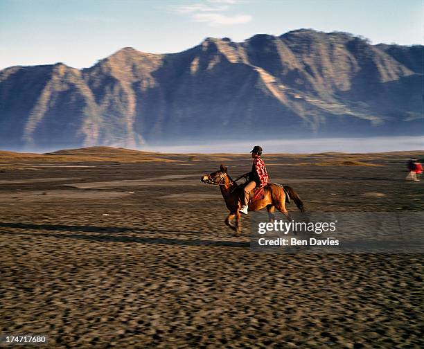 At dawn, a villager on horseback gallops across the sands at Mount Bromo, the spectacular volcanic peak that is situated high up in the Tengger...