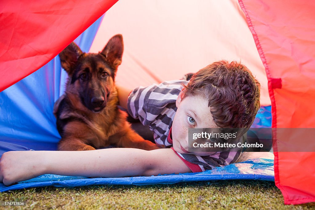 Child and pet dog inside a camping tent