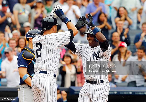 Alfonso Soriano of the New York Yankees celebrates his third inning two run home run against the Tampa Bay Rays with teammate Derek Jeter at Yankee...