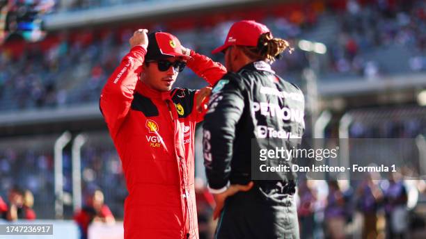 Pole position qualifier Charles Leclerc of Monaco and Ferrari speaks to third placed qualifier Lewis Hamilton of Great Britain and Mercedes in parc...