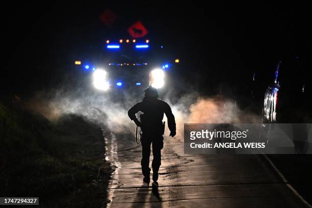 Law enforcement are seen outside the home of suspect Robert Card's father and brother in Bowdoin, Maine on October 26 in the aftermath of a mass...