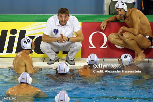 Nebojsa Novoselac, head coach of Germany talks to his players during the Men's Water Polo quarterfinals qualification match between Germany and...